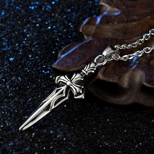 Macro shot of silver vintage sword cross pendant with gothic hollow carving and metal chain
