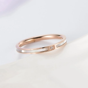 Detail eines Roségold-Rings mit weißer Perlmutt-Einlage und funkelndem Mittelstein