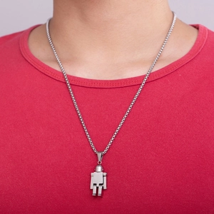 Close-up of a movable silver robot pendant in titanium steel on a red shirt background