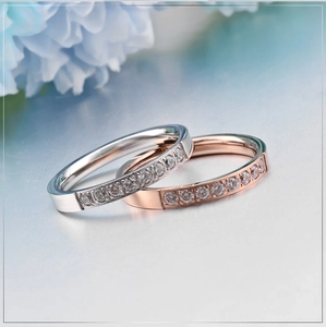 Macro view of rose gold and silver rings with cubic zirconia pavé setting on grey surface