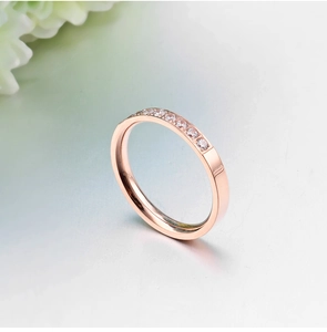 Detailed view of rose gold band set with sparkling round cubic zirconia stones