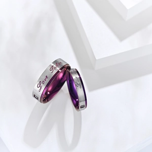 Détail des bagues pour couple en argent brossé avec intérieur violet et gravure 'Love Token'