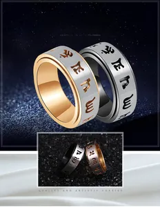Detail of spinning stainless steel ring with engraved Buddhist mantra and brushed finish