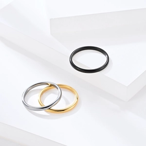 Polished minimalist tungsten steel rings in silver, gold and black on white blocks