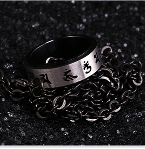 Detailed macro view of rotatable mantra ring with hollow engraved silver and black steel