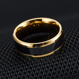 Macro detail of golden temperature ring with black enamel and red I Love You text