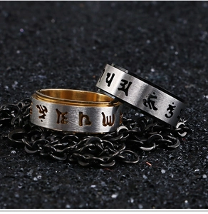 Macro detail of rotating stainless steel spinner ring with engraved Sanskrit characters