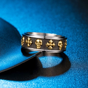 Anello rotante punk con teschi dorati e croci su acciaio nero smerigliato