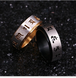 Rotating stainless steel rings with brushed finish and engraved Buddhist mantras on sand