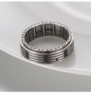 Macro detail of vintage spinner ring with Bagua symbols and Chinese engravings