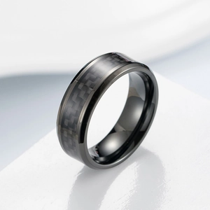 Macro shot of polished black titanium steel ring with textured carbon fiber inlay detail