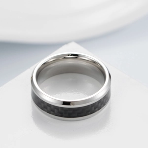 Macro shot of polished titanium steel ring featuring black carbon fiber inlay texture
