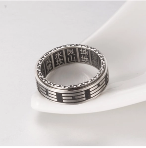 Macro shot of rotatable stainless steel ring with engraved Chinese Baqua symbols and text