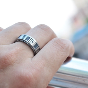 Close-up of vintage Tai Chi ring on finger showing maze texture and stripe details