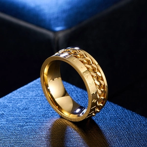 Detalle del anillo giratorio de acero bañado en oro 18K con runas y cadena