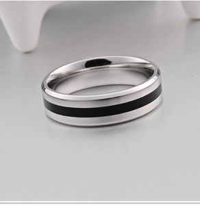Macro d'une bague en acier titane avec bande centrale noire et bords biseautés polis