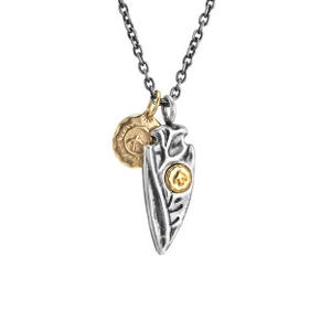 Close-up of vintage industrial arrow and coin pendants on a dark grey chain link necklace