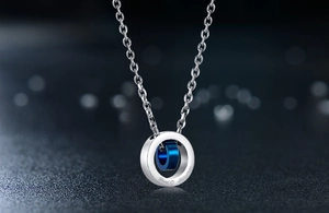Makroaufnahme von Doppelring-Anhänger in Silber und Blau mit feiner Gravur