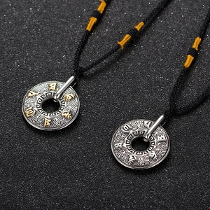Gros plan de pendentifs mantra bouddhistes en acier titane avec motifs de nuages rétro