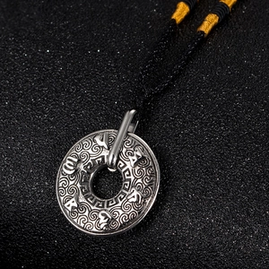 Vue détaillée du pendentif mantra sanskrit vintage avec motifs de nuages de bon augure