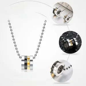 Close-up of triple-layered spinning Roman numeral rings on a steel bead chain necklace
