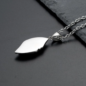 Macro view of polished silver leaf pendant with sleek metal texture on stone