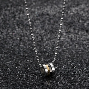 Macro shot of rotatable Roman numeral pendant with silver, gold, and black metal rings
