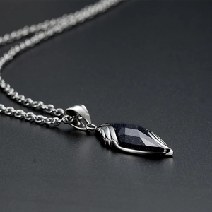 Macro detail of blue sandstone pendant with intricate wing textures on silver setting