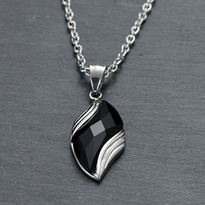 Detailed macro view of silver titanium steel necklace with blue sandstone pendant on stone