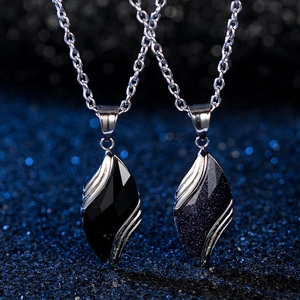 Detailed close-up of blue sandstone and black enamel leaf pendants on silver chain necklaces