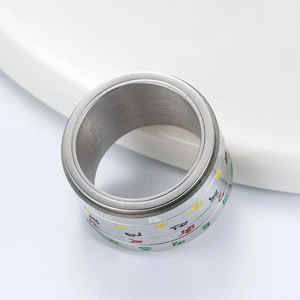 Détail d'une bague rotative en acier inoxydable avec gravures tibétaines colorées