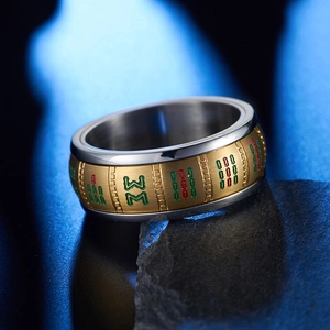 Close-up of rotating Mahjong ring with brushed gold texture on a dark stone