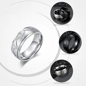 Detail of black and silver brushed rings with engraved V-shape geometric patterns