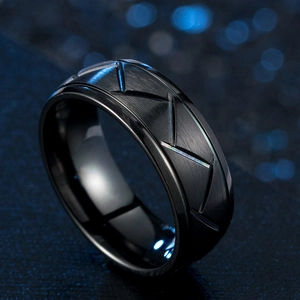 Macro detail of men's black titanium ring with brushed finish and geometric V-lines