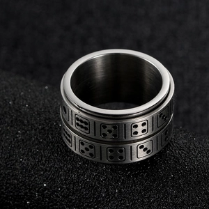 Macro shot of rotatable stainless steel ring featuring engraved gaming dice dot patterns