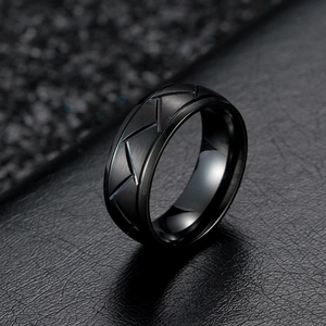 Close-up of matte black titanium steel ring featuring geometric engraved diagonal lines