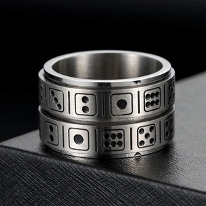 Macro detail of rotating stainless steel ring featuring engraved dice dot patterns
