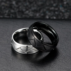 Brushed black and silver titanium steel rings with V-shaped geometric lines and matte finish