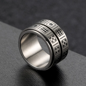 Rotating stainless steel spinner ring featuring engraved dice patterns for stress relief