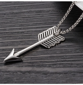 Détail macro du collier pendentif flèche en acier inoxydable avec plume et chaîne box