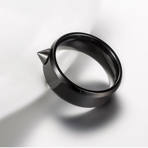 Close-up of black titanium steel ring featuring a sharp conical rivet punk spike design