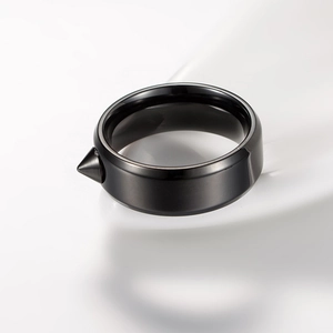 Macro detail of a black titanium steel ring featuring a sharp punk rivet spike design