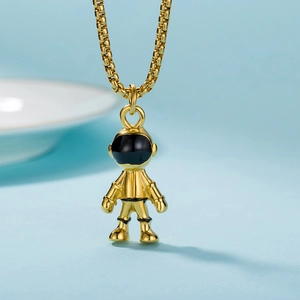 Close-up of golden astronaut pendant with black visor on a textured box chain