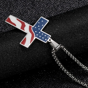 Vue macro d'un pendentif croix en acier avec drapeau américain en émail et chaîne