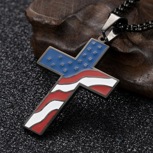 Détail macro d'un pendentif croix en acier inoxydable noir avec motif de drapeau américain