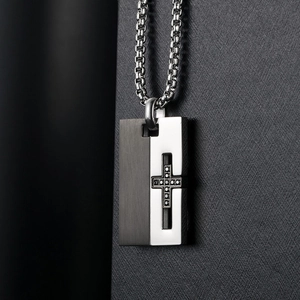 Macro view of bicolor titanium cross pendant with black brushed and silver finish
