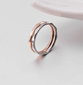 Detail von silbernen und roségoldenen Ringen mit geometrischer Textur und glänzendem Finish
