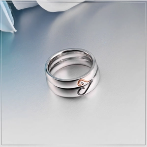 Detail of polished stainless steel couple rings showing heart-shaped side cutouts with crystals