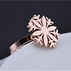 Elegant rose gold laser-cut snowflake ring with polished mirror finish on white pedestal
