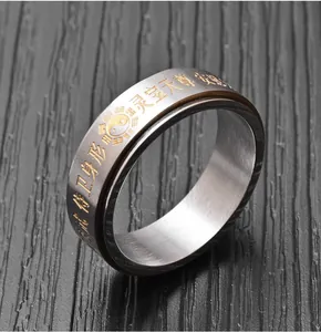 Vue détaillée d'une bague rotative en acier inoxydable avec symboles taoïstes dorés